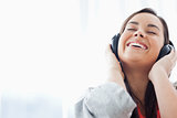 A laughing woman listening to her headphones