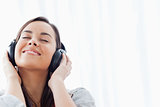 A smiling woman listening to her headphones