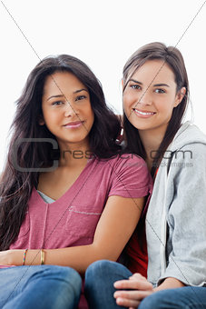 Half length shot of two women lying against each other while loo
