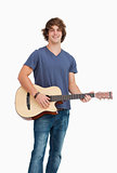 Male student posing while holding a guitar