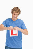 Young man ripping a learner driver sign