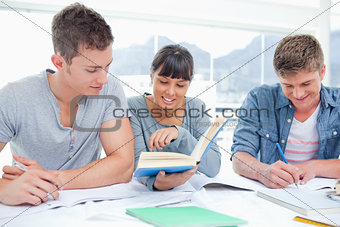 A group of students sitting together as they all study