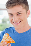 Close up of a man with pizza as he gets ready to eat it