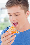 A man looking at a slice of pizza in front of him as he is about