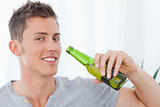 A smiling man with beer near to his mouth