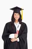 Woman with her degree dressed in her graduation gown 