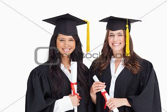 Two friends stand together after graduating