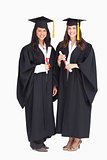 Full length shot of two women graduating