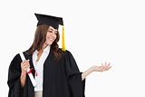A woman holding her hand out with a degree in her other hand as 