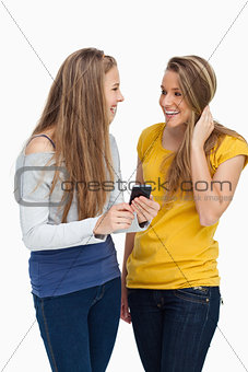 Two females student laughing while holding a cellphone