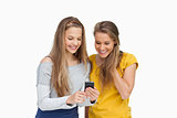 Two smiling students looking a cellphone screen