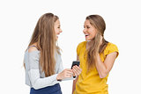 Two surprised young women holding a smartphone