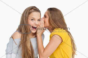Blonde student whispering to her friend