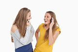 Two young women laughing on the phone together