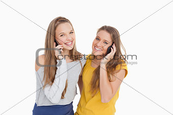 Two young women smiling on the phone