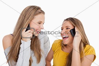 Close-up of two young women laughing on the phone