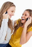 Close-up of two beautiful students laughing on the phone