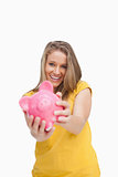 Young smiling woman tending a piggy-bank 