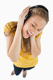 Fisheye view of a blonde girl enjoying music with headphones