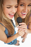High-angle shot of two happy young blonde singing