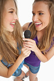 High-angle shot of two happy young beauty singing together
