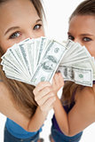 High-angle view of two young woman behind dollars