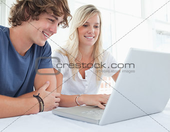 A group of smiling friends looking at the laptop