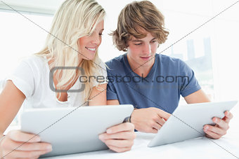 A couple both using tablets
