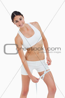 Slim woman measuring her thigh