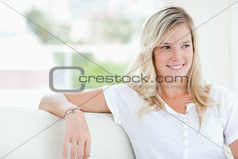 A smiling woman looking to the side as she sits
