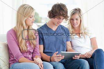 Three people pay attention to the tablet in front of them