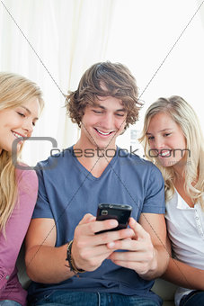 man showing the two girls whats on his phone