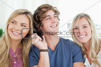 Three friends listening to a phone conversation 