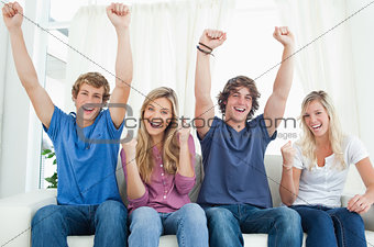 A group of friends celebrate together while looking at the camer