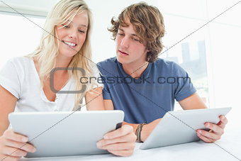A man looking into his girlfriends tablet