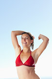 Smiling woman in bikini stretching