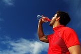Thirsty fitness man drinking water with red shirt