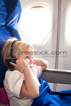 child with headphones in the plane