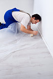 Worker laying protection film before painting