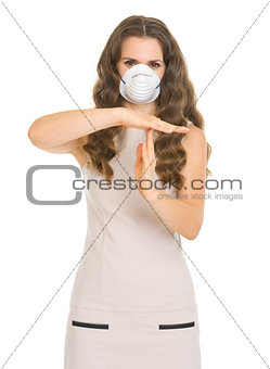 Young woman in mask showing stop gesture