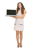 Happy young woman showing laptop