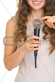 Closeup on young woman tapping on microphone to check sound