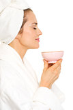 Young woman in bathrobe enjoying cup of tea