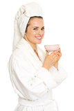 Smiling young woman in bathrobe with cup of tea
