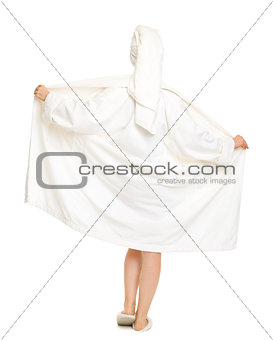 Full length portrait of woman taking off bathrobe. Rear view