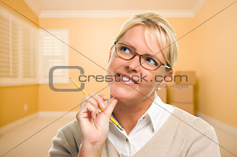 Daydreaming Woman with Pencil in Empty Room and Boxes