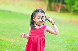 Little Asian girl with magnifier glass