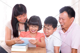  Parents and children using tablet pc together.
