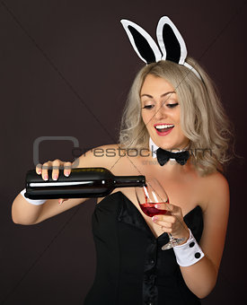 Playful girl at the party pours wine