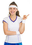 Happy tennis player pointing on copy space